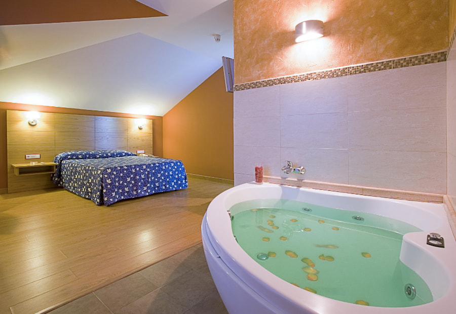 Room with double bed and hydromassage bathtub