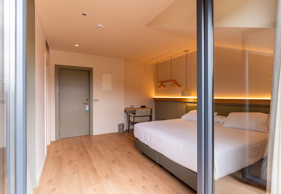 Habitación doble superior vista desde el balcón Habitación doble superior moderna con cama king size, escritorio y lámparas de diseño