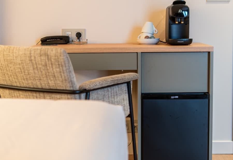 Habitación triple superior detalle amenities Habitación triple superior detalle cafetera, teléfono y mini nevera