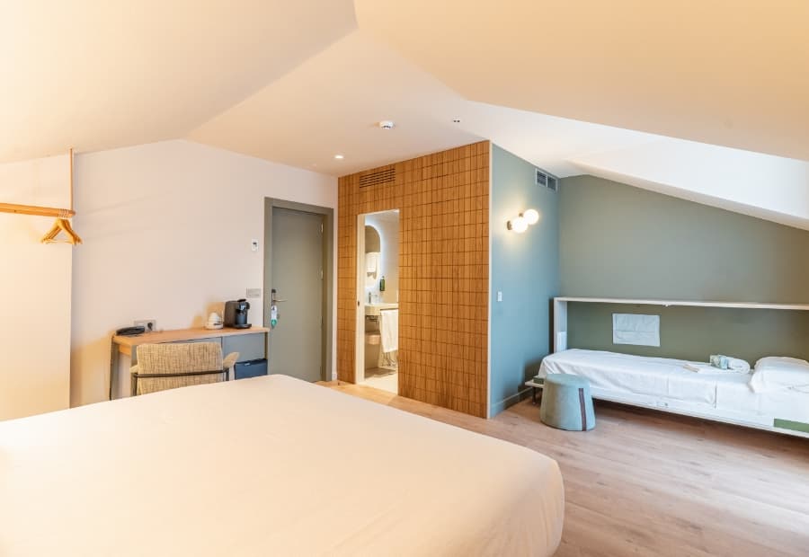 Habitación triple superior vista genérica 2 Habitación triple superior con cama supletoria, escritorio y amenities