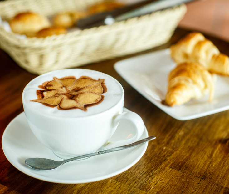 Desayuno de croissant i taza de café con leche